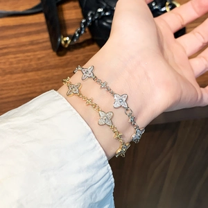 Elegant gold and silver four-leaf clover zircon bracelet worn on a female wrist