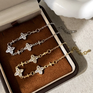 Detailed view of silver and gold flower bracelets with sparkling zircon stone inlays