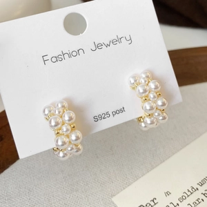 Elegant C-shaped earrings with high-luster pearls and S925 silver posts on a display card