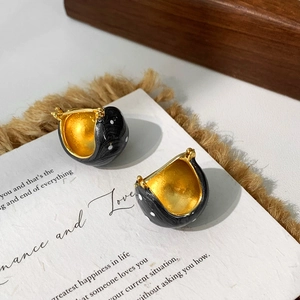 Detailansicht der Vintage Emaille-Ohrringe in Schwarz mit weißen Punkten und Goldfinish