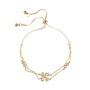 Gold double-chain clover bracelet with heart-shaped cat-eye stones and adjustable bolo clasp