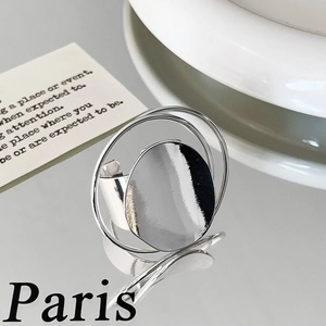 Macro shot of silver oversized disc ring with triple layered bands on a mirrored surface