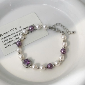Vue détaillée du collier de perles avec pendentif en pierre violette et fermoir mousqueton