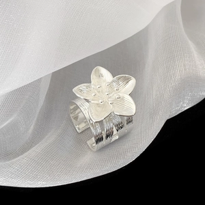 Detailed macro view of a silver floral multi-layer open ring with textured petals