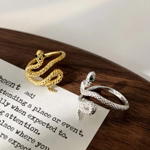 Adjustable snake-shaped rings in gold and silver finish with green gemstone eyes