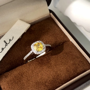 Macro shot of a cushion-cut yellow gemstone ring with a halo of small diamonds