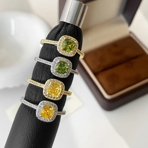 Detailed macro view of four stackable rings with cushion-cut yellow and green zircon stones