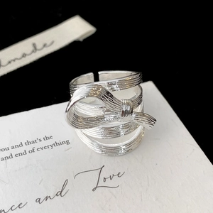 Détail d'une bague nœud argentée aux textures multicouches et métal brossé fini