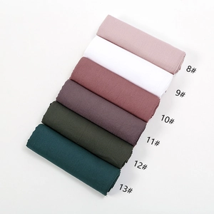 Detailopname van geplooide sjaals van katoenmix in diverse effen kleuren textuur