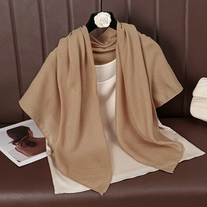 Close-up of light brown cotton linen scarf showing soft fabric texture and elegant drape