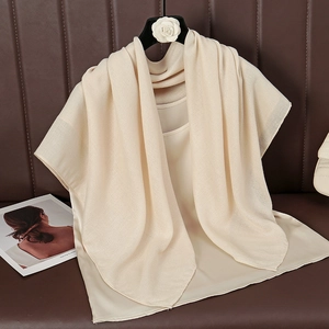 Detail showing high-quality beige cotton-linen scarf fabric with natural drape and texture