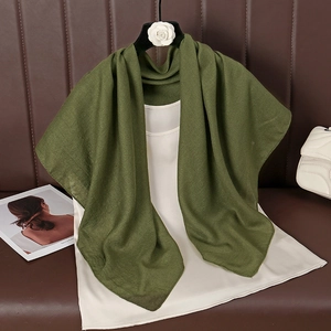 Detailed texture of dark green cotton linen scarf hanging on a rack for summer styling