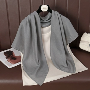 Detail of dark grey premium cotton linen scarf draped on a white sleeveless top
