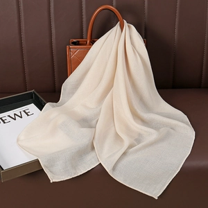 Lightweight cream solid linen scarf draped elegantly on a handbag for a chic summer look