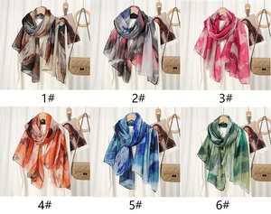 Detail view of six floral print scarves in various colors with elegant artistic patterns