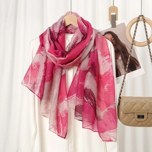 Detail view of pink marble print lightweight chiffon scarf draped over a white shirt