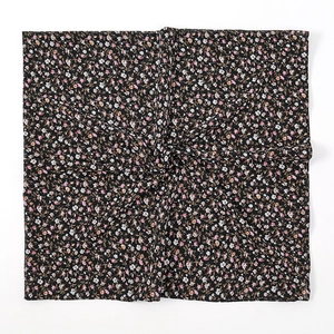 Detail van de vierkante chiffon hijab met elegante roze bloemenpatronen en fijne textuur