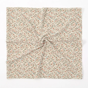 Detailtextuur van vierkante chiffon sjaal met dichte vintage bloemenprint op beige weefsel