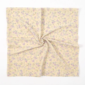 Macro-opname van de bloemige chiffon sjaaltextuur met gele stof en paarse bloemen