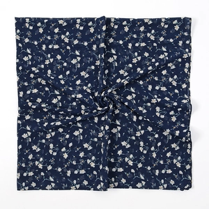 Detail van marineblauwe chiffon hijab met witte bloemenprints en gedraaide textuur