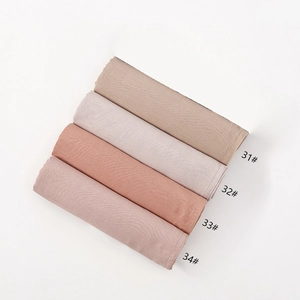 Detail showing flat-laid modal scarves in four solid colors with fine edge stitching