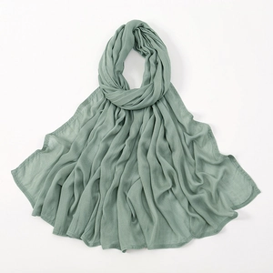 Close-up of sage green modal hijab featuring vertical pleated texture and neat edges
