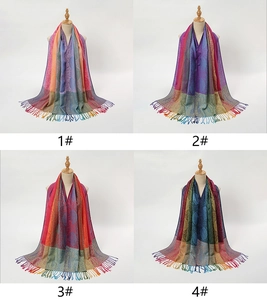 Dettaglio di quattro scialli con frange paisley colorati con motivi sfumati per donna