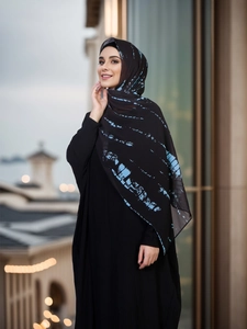 Detailed view of lightweight chiffon hijab with blue abstract tie-dye print and black abaya
