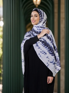Detail of ethnic blue tie-dye chiffon hijab with ripple patterns on a white base