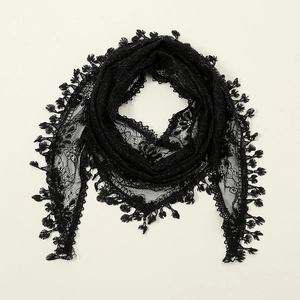 Détail d'un foulard triangle en dentelle noire avec motifs floraux ajourés et bords à franges