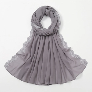 Detailansicht eines grauen Chiffon-Kopftuchs mit feiner silberner Spitzenbestickung