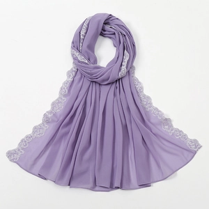Detail eines hellvioletten Schals aus Chiffon mit elegantem weißem Spitzenbesatz