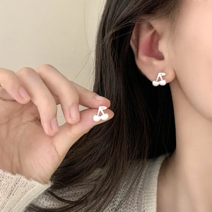 Elegant cherry-shaped stud earrings with silver stem and white pearls on model