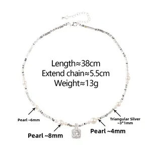 Detail of beaded necklace with white pearls, silver beads and a square crystal pendant