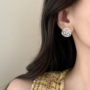 Elegant gold and silver hollow lace earrings shown on a model wearing tweed clothes