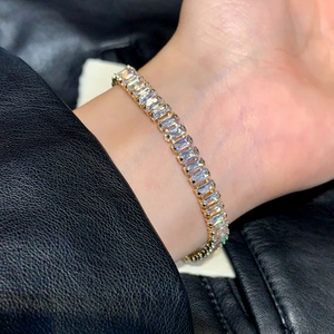 Elegantes Goldarmband mit rechteckigen Zirkonia-Kristallen getragen an einem Handgelenk