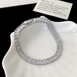 Nahaufnahme eines silbernen Tennisarmbands mit Zirkonia-Steinen in einer Muschelschale