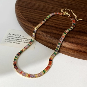 Détail d'un collier en zircons arc-en-ciel avec chaîne dorée et fermoir mousqueton