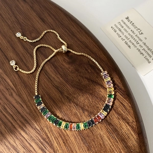 Gros plan détaillé d'un bracelet doré réglable serti de zircons multicolores sur bois