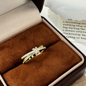 Elegant gold-tone crisscross ring with micro-pave cubic zirconia and clover motif