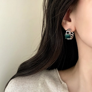 Vintage emerald zircon stud earrings with silver chain design worn by a model