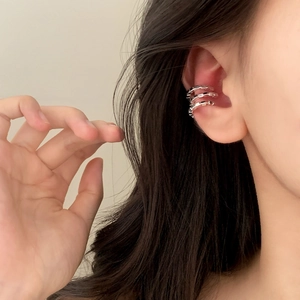 Minimalist silver triple-layer textured ear cuff shown on a model ear in a side view