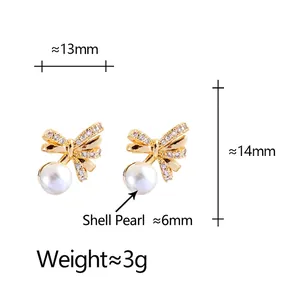 Elegant gold bow earrings with zircon stones and white shell pearls on white background