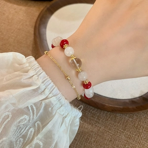 Bracciale retrò multistrato con pietre naturali e perle dorate sul polso di una donna