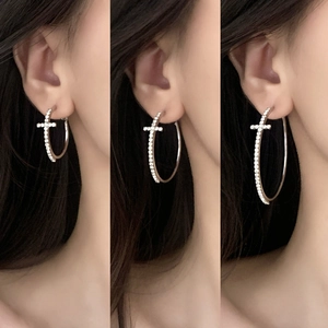 Sparkling zircon cross hoop earrings in silver, showing three sizes on model ear