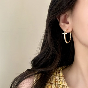 Eleganti orecchini a cerchio dorati con pendente a croce in zirconi per un look di classe