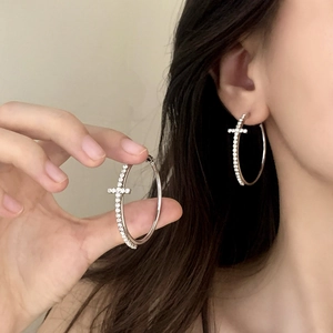 Silver hoop earrings with sparkling zircon crosses shown on model for size perspective