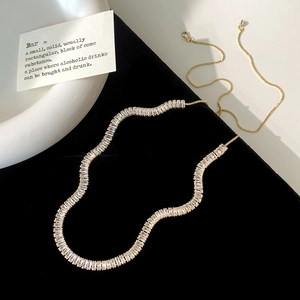 Detail of elegant gold necklace featuring rectangular zircons and adjustable box chain