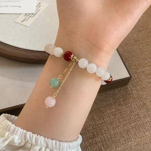 Retro style beaded bracelet with red stone and white pearls featuring gold chain accents