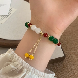 Elegante bracciale retrò con perle di calcedonio verde e ciondoli dorati al polso